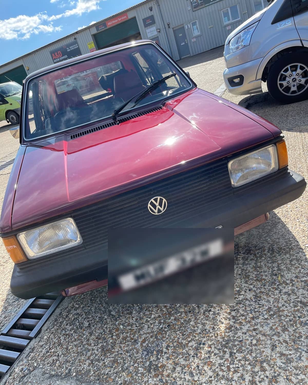 Front end of a restored maroon Volkswagen Mk1 Jetta, paintwork flawless in the sun