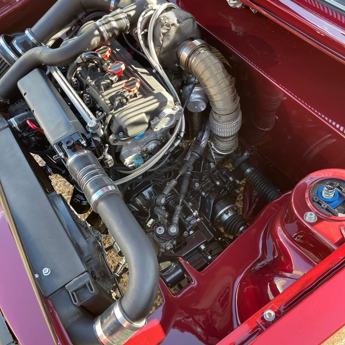 Turbocharged engine bay of a maroon Volkswagen Mk1 Jetta, painted and finished throughout