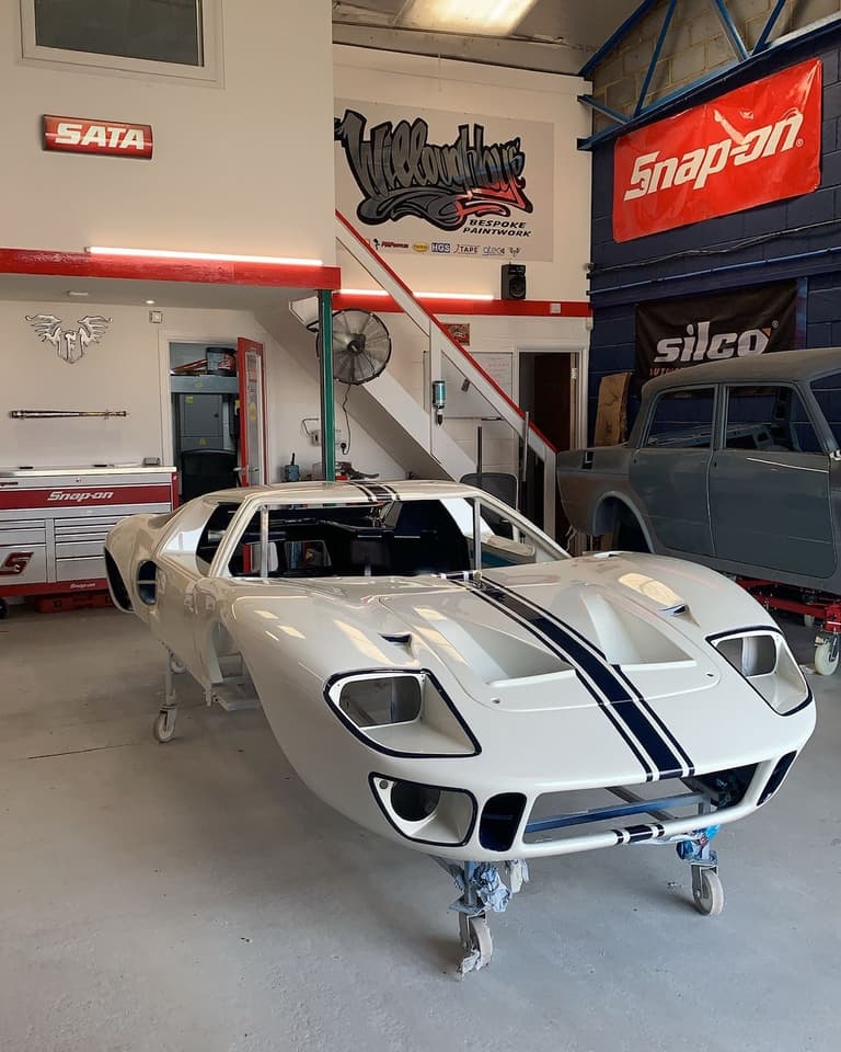 Bare white Ford GT40 shell standing in the workshop before final paint