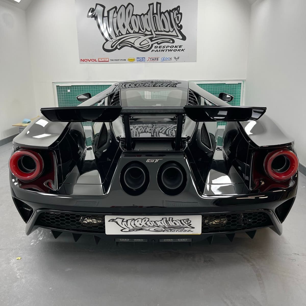 Rear of a Ford GT in the spray booth, tail lights and quad exhaust