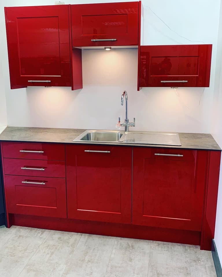 Hand-sprayed high-gloss red kitchen units with a stainless steel sink