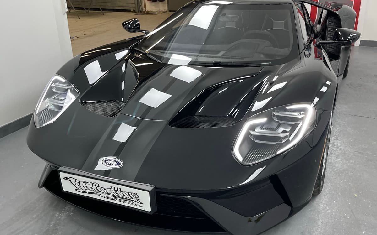 Dark Ford GT with silver stripes, photographed front three-quarter after respray